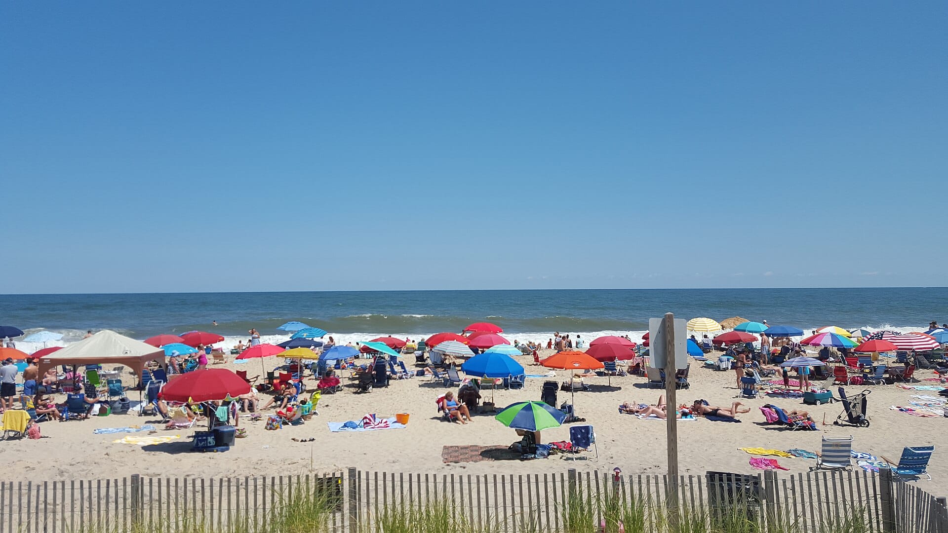 Colourful beach umbrellas and families on the sand at Bethany Beach, Delaware